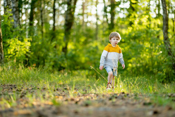 Cute little boy having fun outdoors on sunny summer day. Child exploring nature. Kid going on a trip. - 793871460