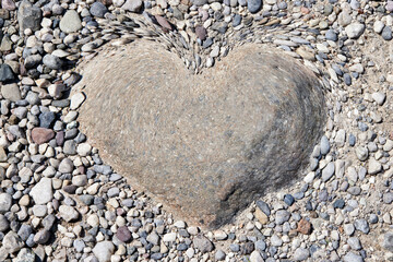 heart on stones in the quay - obrazy, fototapety, plakaty