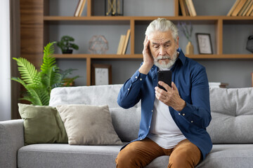 Senior man receives unsettling news on his smartphone at home