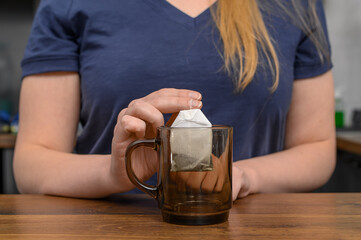 Torebka herbaty ekspresowej w szklanym przezroczystym kubku  - obrazy, fototapety, plakaty