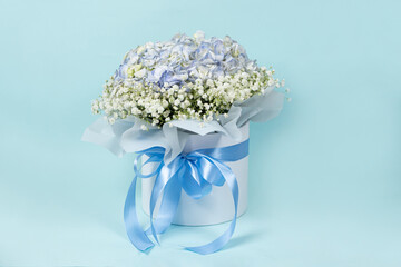 Bouquet of flowers made of hydrangeas and gypsophila in a white box with a bow