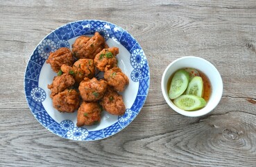 deep fried fish patty on plate with slice cucumber dipping sweet chili sauce 