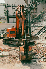 A red excavator works at a construction site