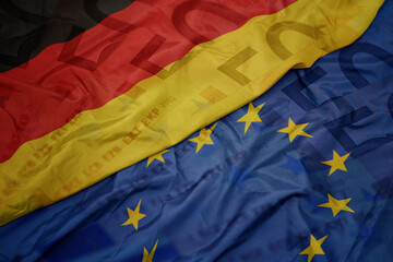 waving colorful flag of european union and national flag of germany.finance concept.