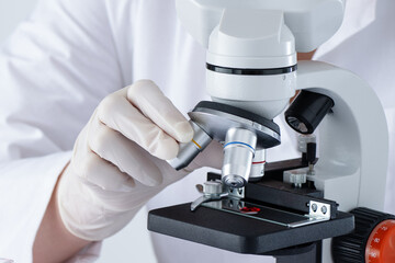 A person is using a microscope in medical laboratory to examine blood. DNA blood test. - 793907295