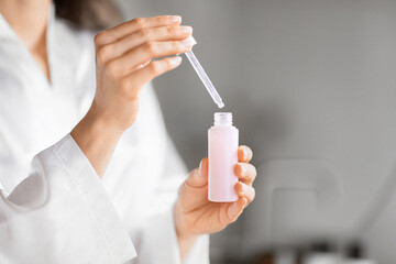 Close-up of woman hands holding skincare dropper