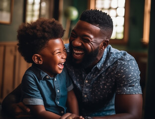 Happy black father holding his son and laughing at home