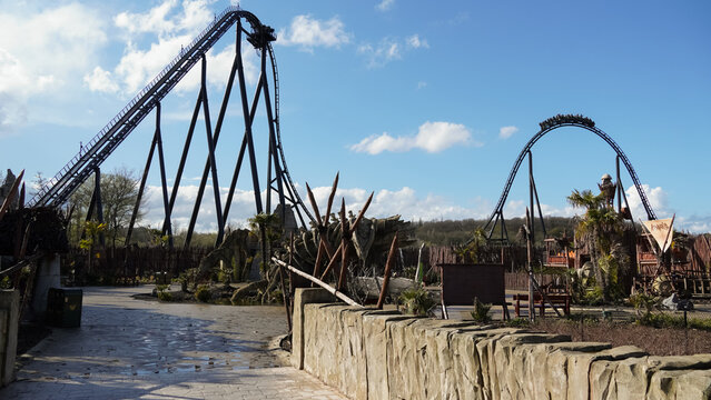 Wavre, Belgium- April 12.2023: Rollercoaster "Kondaa" with train on airtime hill and themed area in front of it, in the amusement park "Walibi Belgium"