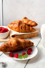 Cup of coffee and croissants and berries. on white wooden. breakfast. Morning.