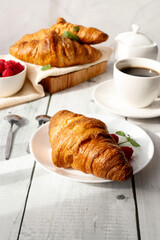 Cup of coffee and croissants and berries. on white wooden. breakfast. Morning.