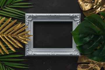 Creative layout with gold and green tropical palm leaves with white frame on black background....