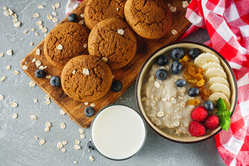 tasty nutritious oatmeal with fruits and berries on a light stone background