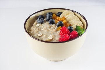 tasty nutritious oatmeal with fruits and berries on a white background