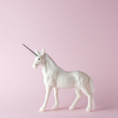 Creative composition with glitter unicorn on pink background. Minimal holiday concept.