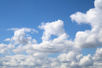 An endless blue sky with white clouds floating over the horizon. Panoramic view of the cloudy sky. Cumulus white clouds. Cloudy weather.