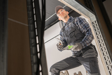 Caucasian Construction Site Worker Patching a Drywall.
