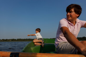 Father and child riding a paddle boat on a lake in summer in the evening