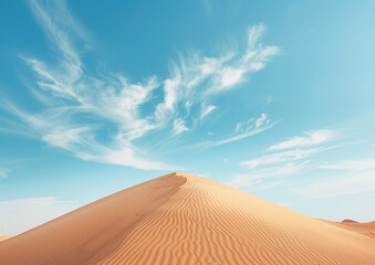 Fototapeta na wymiar A desert landscape with a large sand dune and a clear blue sky