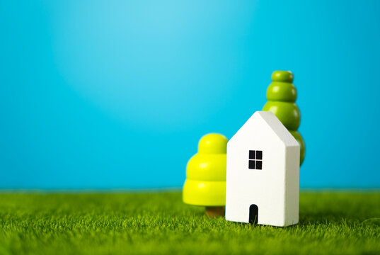 Cute figurines of houses and trees. Mortgage loan. Affordable housing. Housing search and realtor services. Buy a nice house.