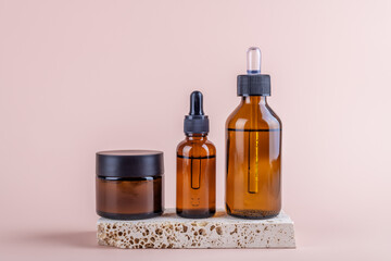 Amber glass jar mockup with face cream and two transparent amber glass dropper bottles mockup for...
