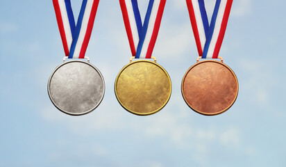 Collection of real gold medals isolated on blue sky background with a lot of text area - winner copy space concept