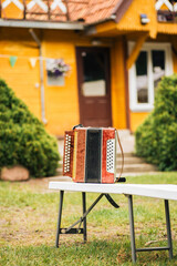 an accordion stands on a bench in the yard