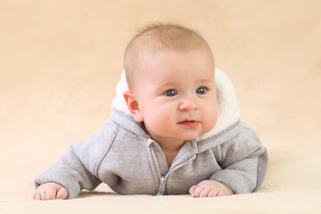 Cute joyful baby on a beige background.