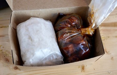 Wrapped cooked white rice and sausage blackpepper sauce in plastic bag take away online food...