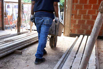 Bricklayer loading wheelbarrow at construction site.
Construction worker. Builder. Concept of...