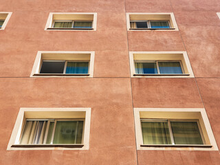 Exterior of modern light orange or ocher urban housing block with apartments