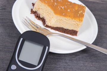 Glucometer and sweet cheesecake. Measuring and sugar level control during diabetes