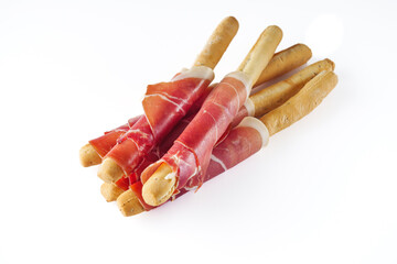 crispy grisini with prosciutto on a white background