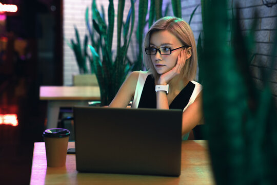 Mindful beautiful young businesswoman in glasses and smartwatch sitting at the table look away with notebook and cup of coffee on it at cafe with ornamental green plants