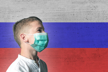 Boy in a medical mask on his face on background of Russia flag. Epidemic virus 2019-nCoV...