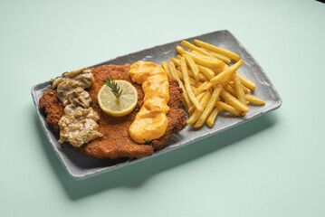 Crispy crumbed flattened Chicken breast served with French fries, mushrooms and cheese sauce