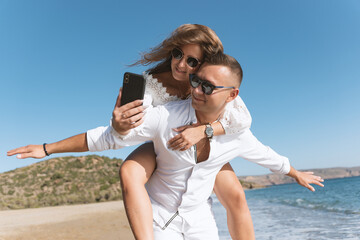Young happy couple taking selfie on the beach. Summer vacations concept.