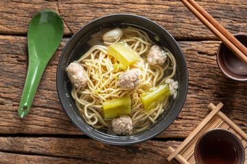 Yellow noodles in clear broth with bitter melon and ground pork