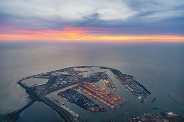 Aerial airplane view of Rotterdam sea port terminal, with many docks, ships and quay's in manmade...