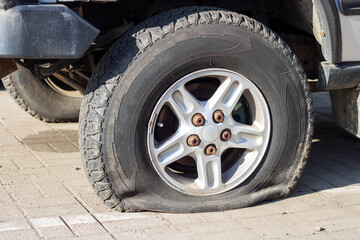 A flat tire on road side, car wheel stuck, needs repair