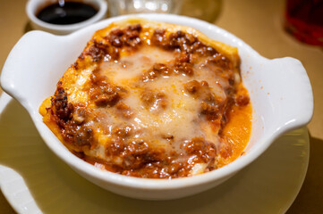 Traditional first course for lunch or dinner in Italy, lasagne Bolognese with beef meat and bechamel sauce served in Italian restaurant, Milan, Italy