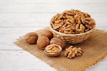 Walnuts in Wooden Bowl or Wicker Basket. Whole Walnut on White Table with Burlap