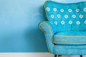 A colorful retro-style armchair against a textured blue wall, ideal for interior design themes and...