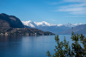 Driving car along shores of Lake Como in Northern Italy, spring sunny days, views of alpine mountains, water and villages