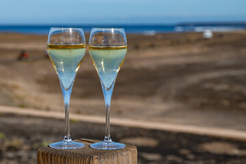 Pouring a glass of champagne on vacation, south of Fuerteventura, Canary islands, blue ocean, mountains