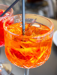 Aperol Spritz orange bitter long drink cocktail made with liqueur, prosecco sparkling wine, ice cubes and piece of orange, Milan, Italy