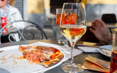 Glass of cold dry white wine served outdoor in cafe in Bellagio, Como lake, Italy