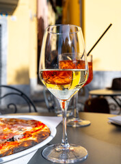 Naklejka premium Glass of cold dry white wine served outdoor in cafe in Bellagio, Como lake, Italy
