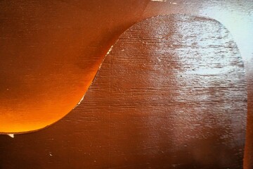 Orangebraune Holzwand mit Wellenmuster und Licht als Hintergrund