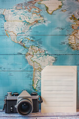 A blank note with for travel plan, positioned next to a world map and camera. This image can evoke themes of adventure, exploration, and wanderlust