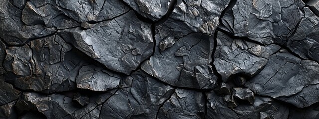 A close-up of interlocking dark slate stones with varying textures.